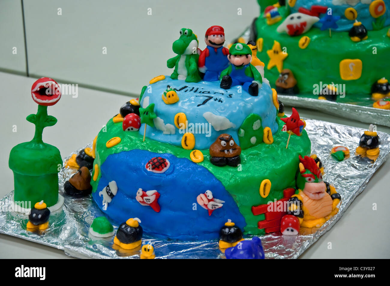 Questo stock immagine ha a casa Mario a tema e decorate a due strati di torta di compleanno, tutti fatti a mano utilizzando ghiaccio fondente. Foto Stock