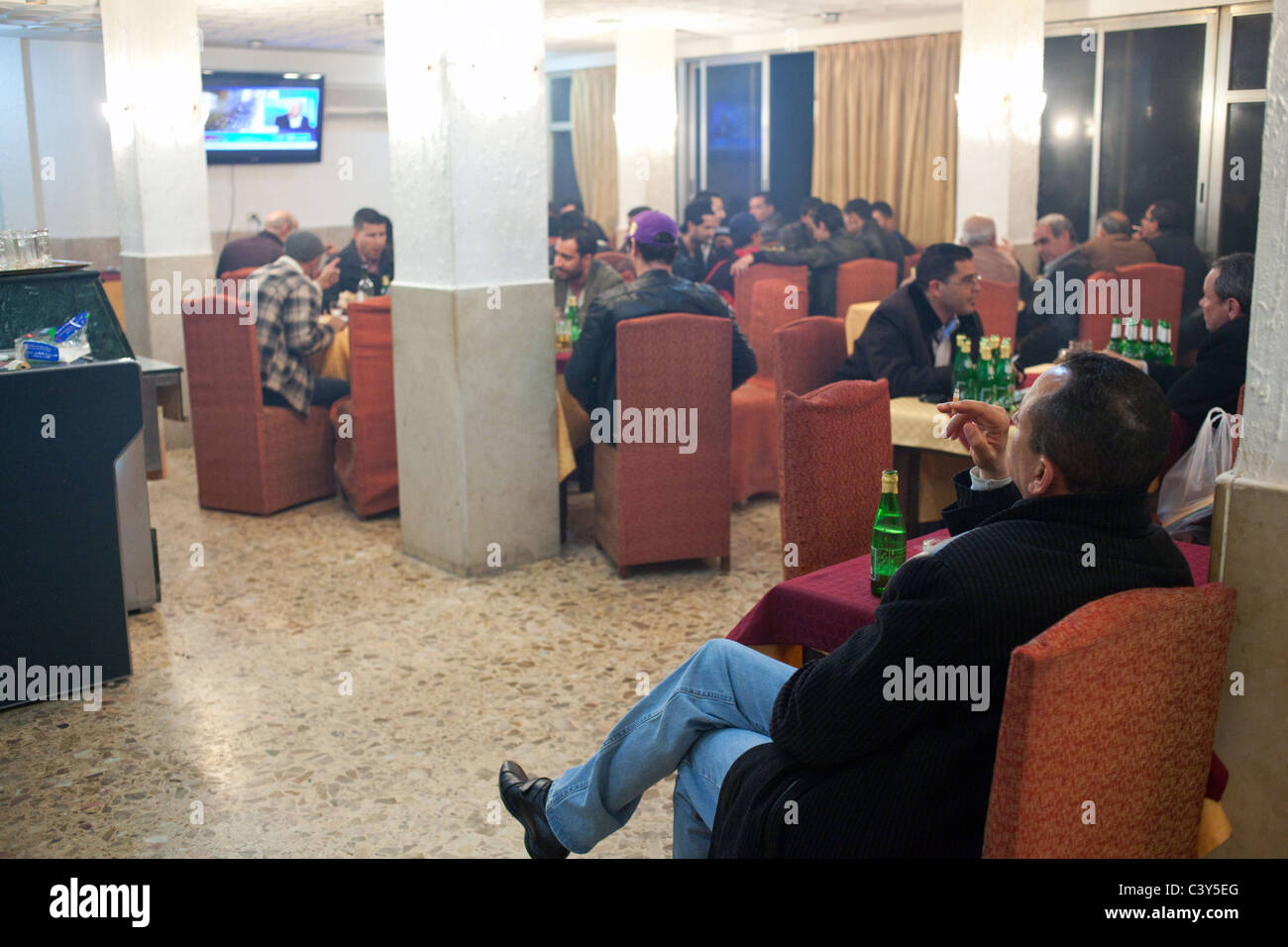 Persone bere alcolici e fumare sigarette un venerdì sera nel bar dell Hotel Le Colisee a Sfax, Tunisia. Foto Stock