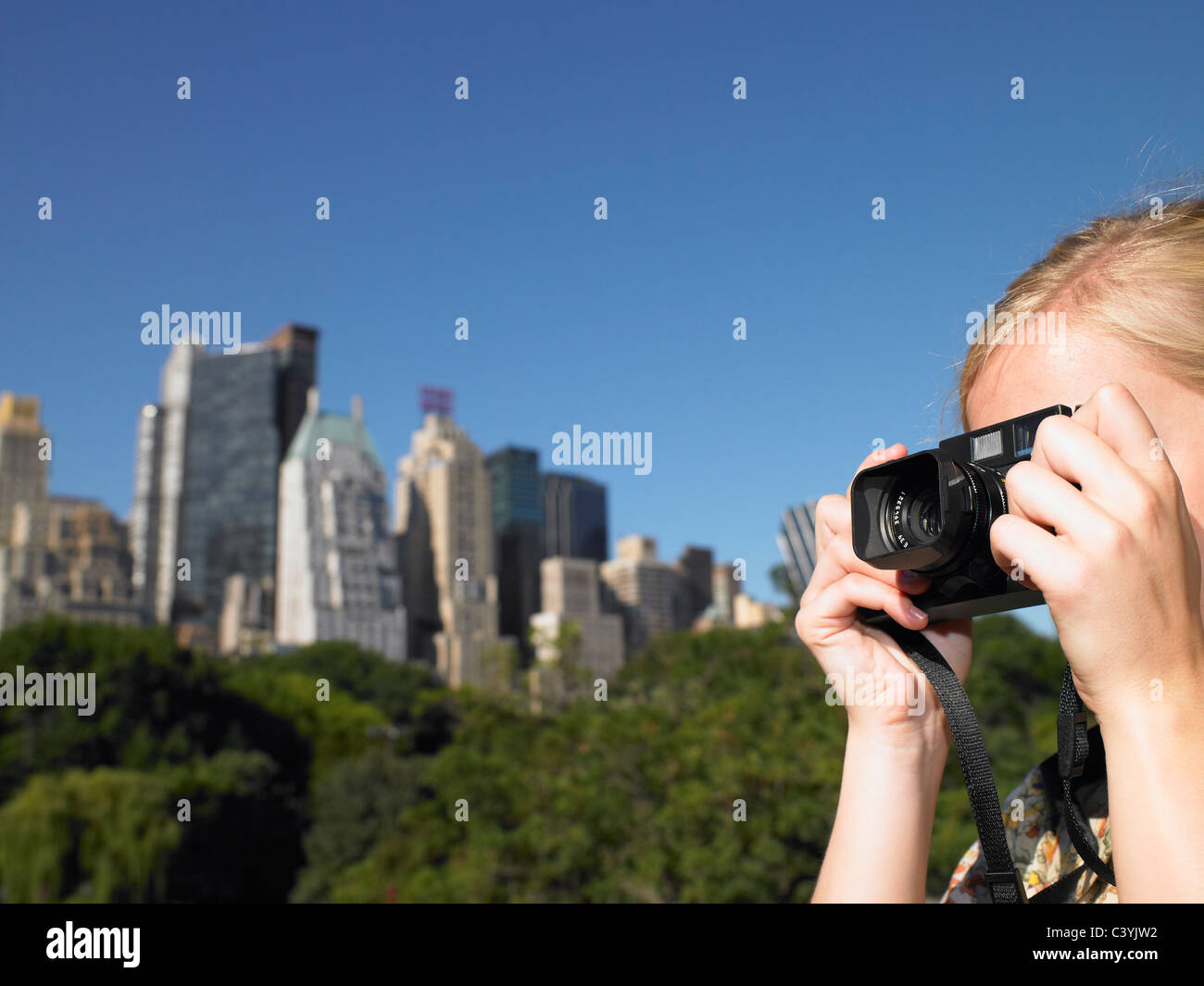 La donna a scattare foto in central park Foto Stock