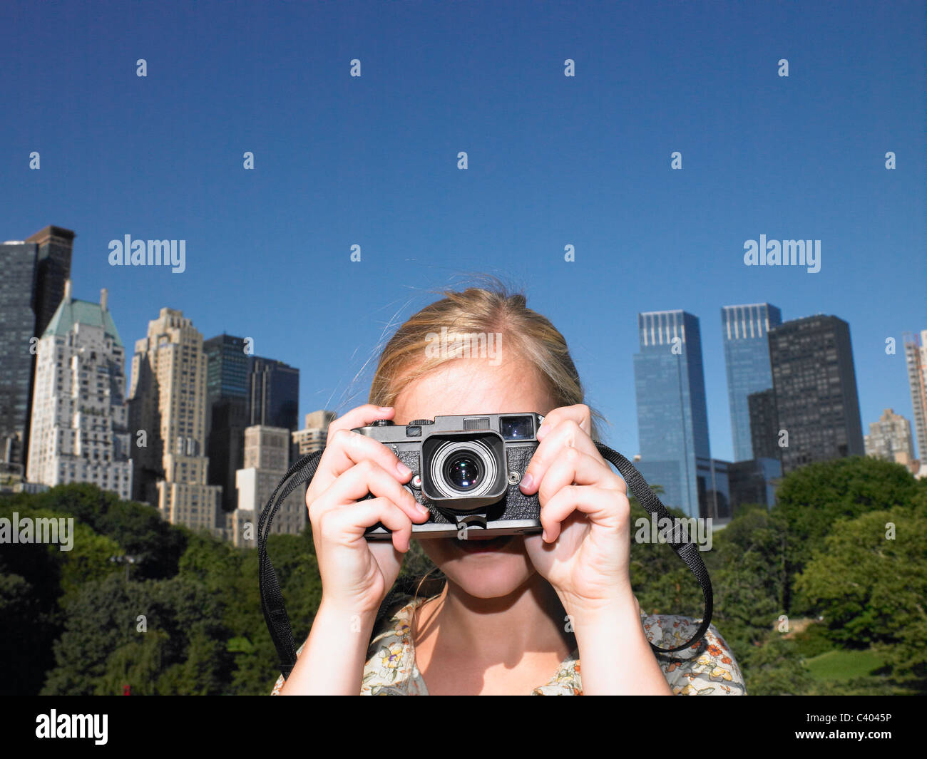 La donna a scattare foto in central park Foto Stock