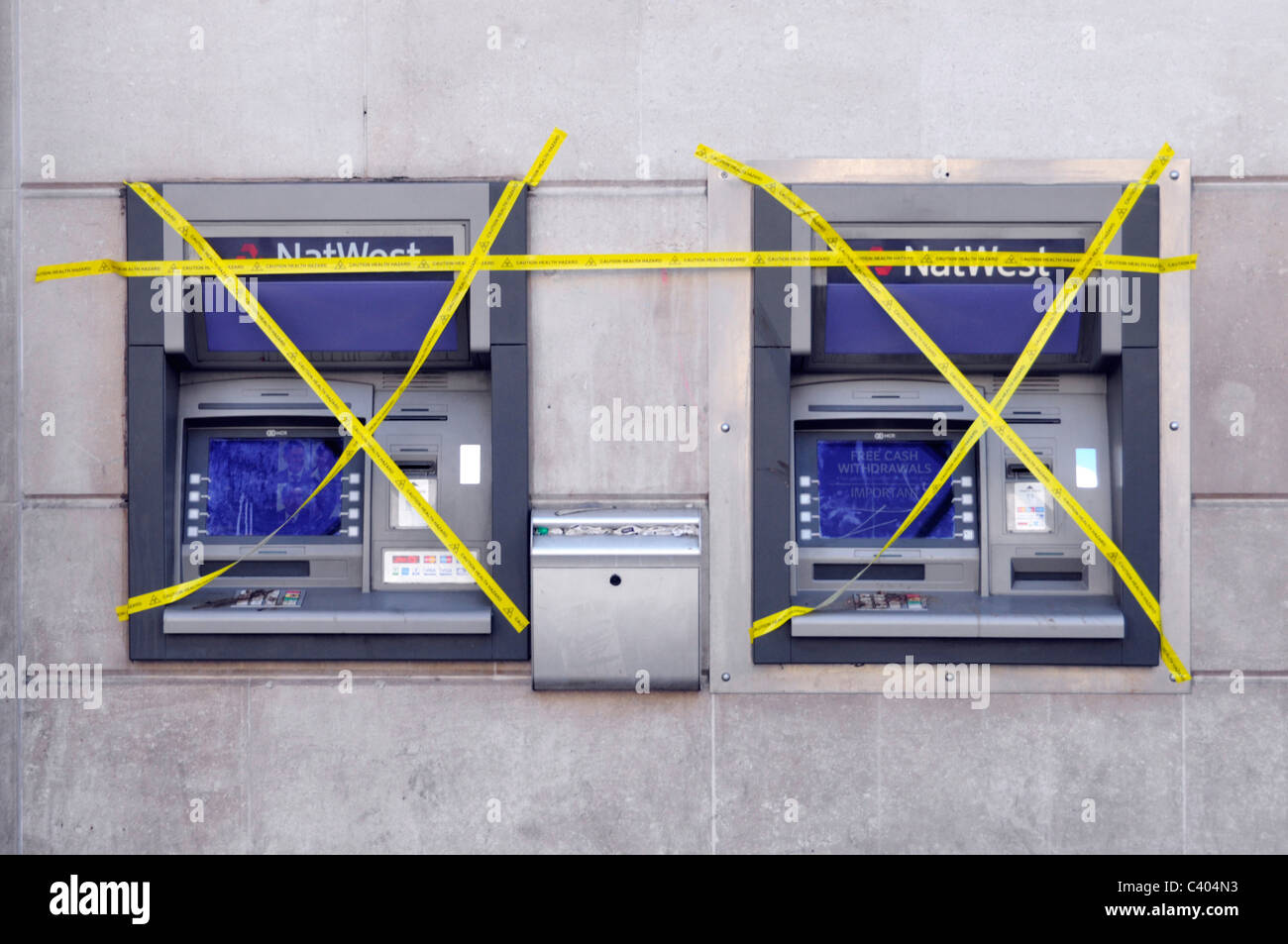 NatWest banca filiale locali esterno bancomat esterno due buco fuori ordine in parete coperto in nastro giallo Charing Cross London Inghilterra UK Foto Stock