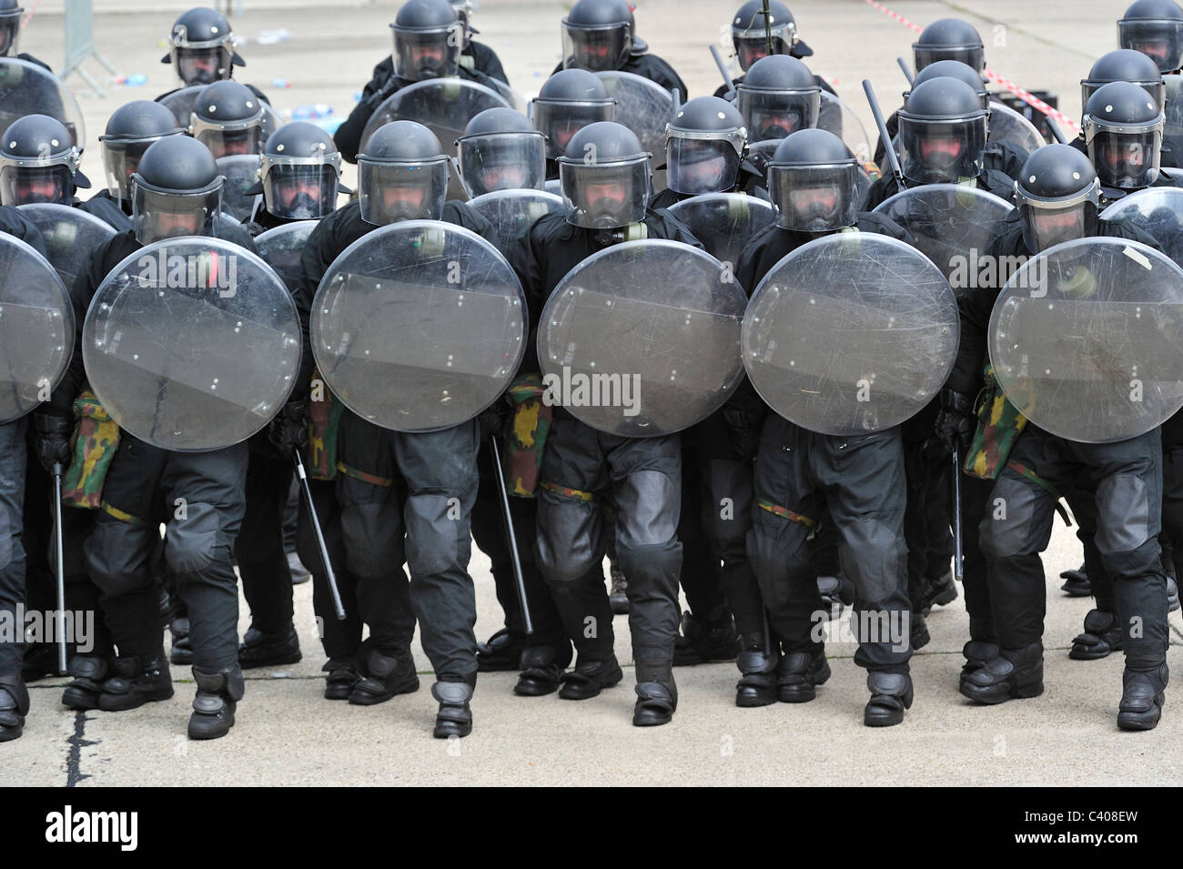Squadra antisommossa poliziotti formando una barriera protettiva con scudi antisommossa durante l'esercizio dell'esercito belga, Belgio Foto Stock