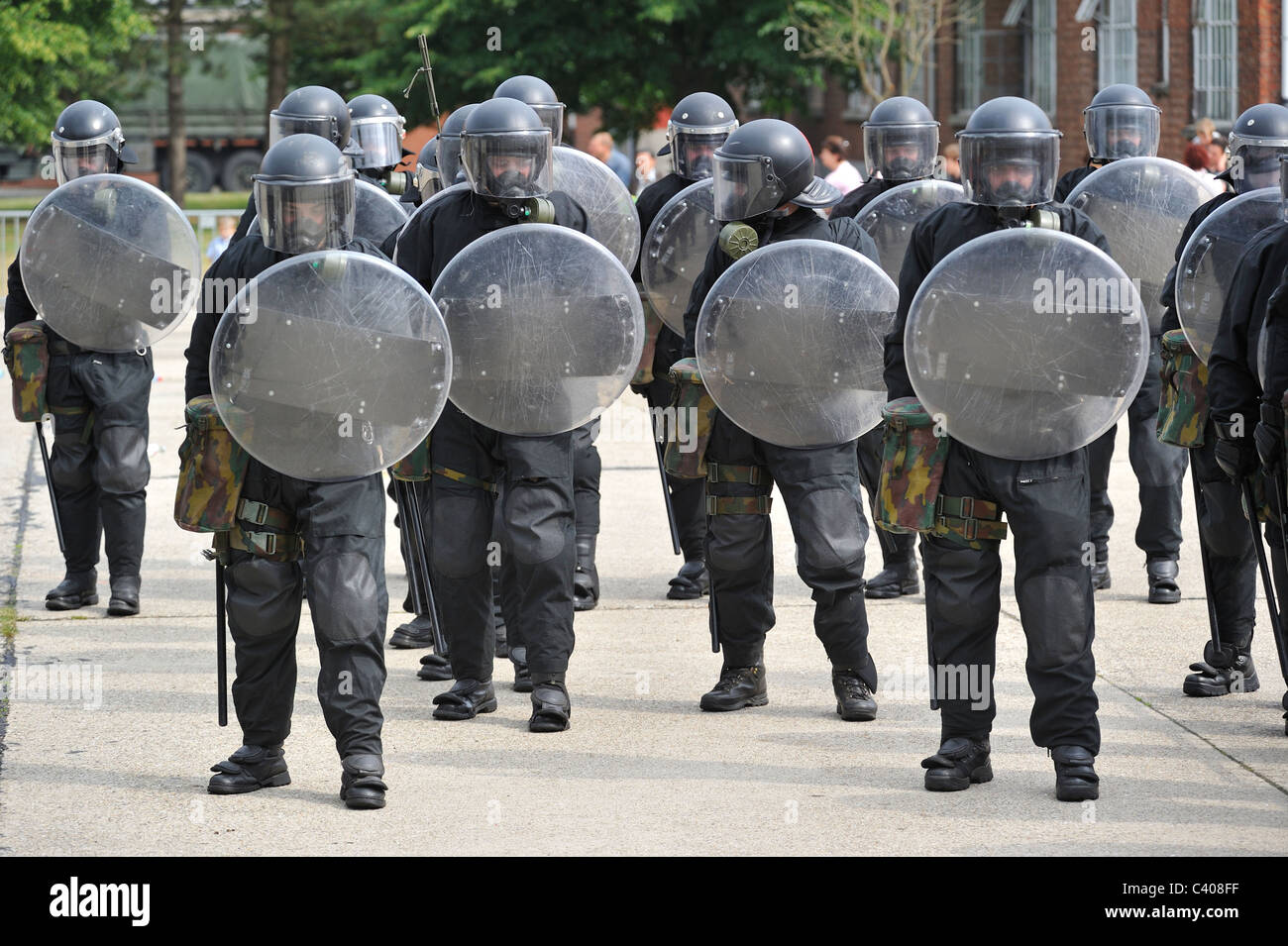 Squadra antisommossa poliziotti formando una barriera protettiva con scudi antisommossa durante l'esercizio dell'esercito belga, Belgio Foto Stock