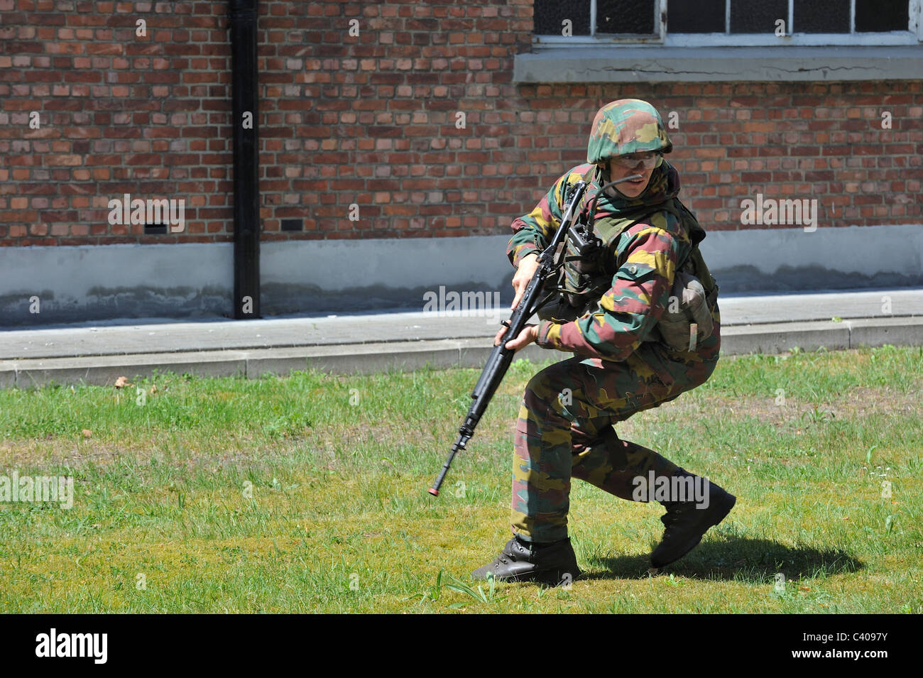 Soldato con FN FNC fucile da assalto di pattuglia a piedi in strada durante l'esercizio dell'esercito belga a Leopoldsburg, Belgio Foto Stock