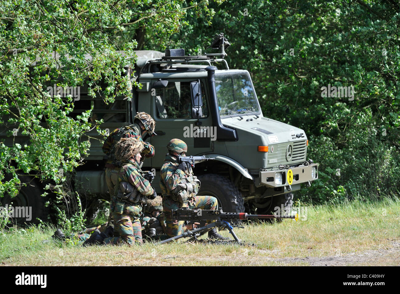 Belga di soldati di fanteria sparando Mi .50 mitragliatrice vicino a U1350L Unimog combattimento blindati veicolo, Belgio Foto Stock