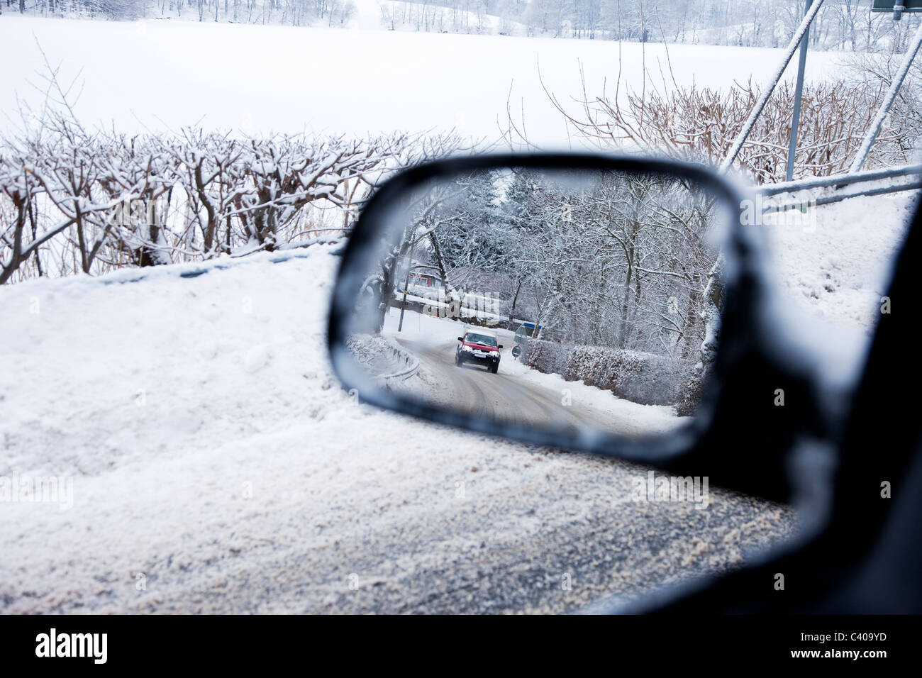 I driver di vista un auto a specchio in una strada in inverno Foto Stock
