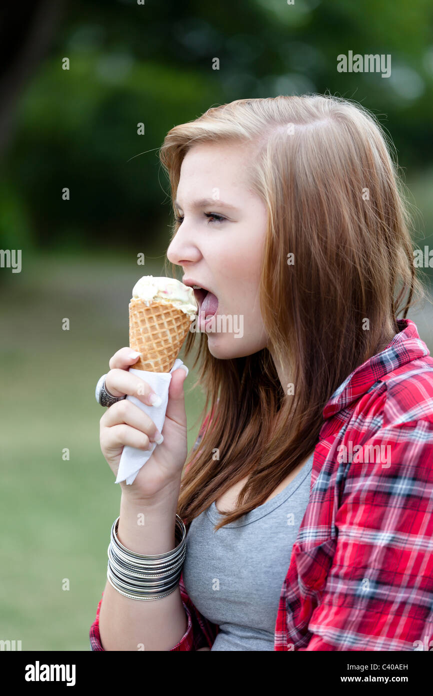 Ragazza adolescente a mangiare il gelato all'aperto Foto Stock
