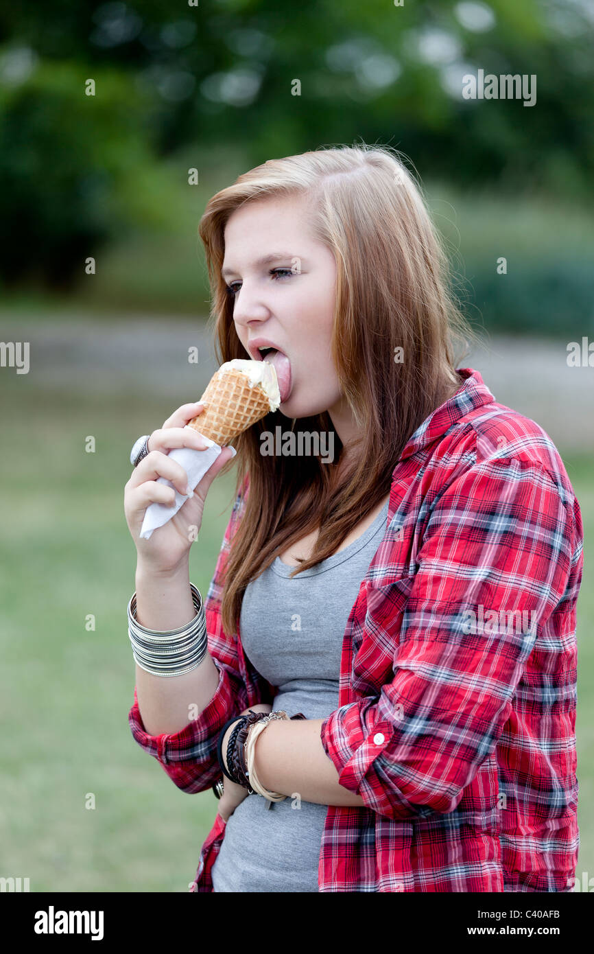 Ragazza adolescente a mangiare il gelato all'aperto Foto Stock