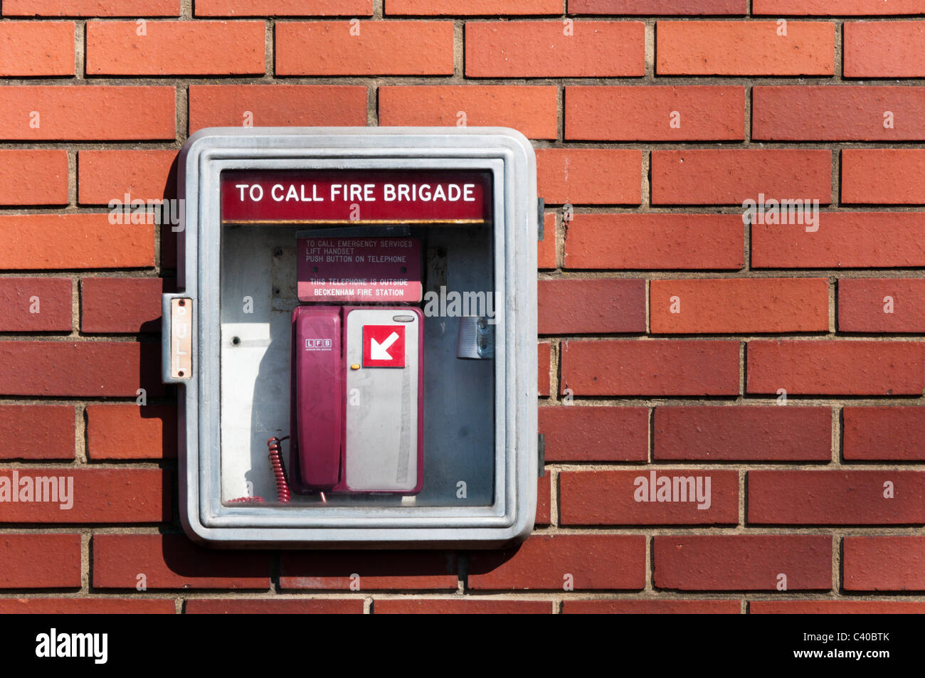 Un telefono di emergenza per contattare i vigili del fuoco all'esterno di una stazione dei vigili del fuoco. Foto Stock