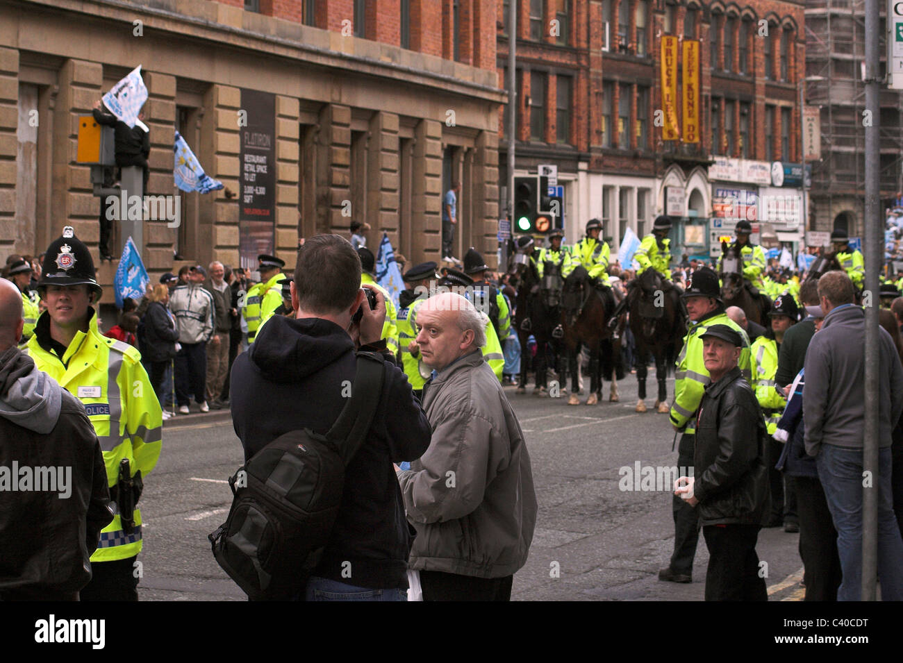 Tifosi e polizia raccogliere lungo Newton Street per il Manchester City Cup Parade, 2011 Foto Stock