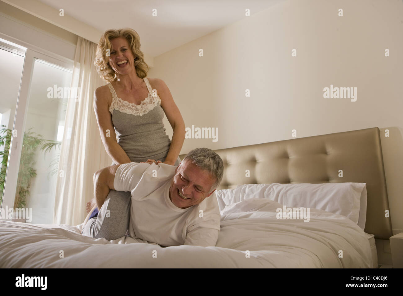 Coppia matura il wrestling sul letto Foto Stock