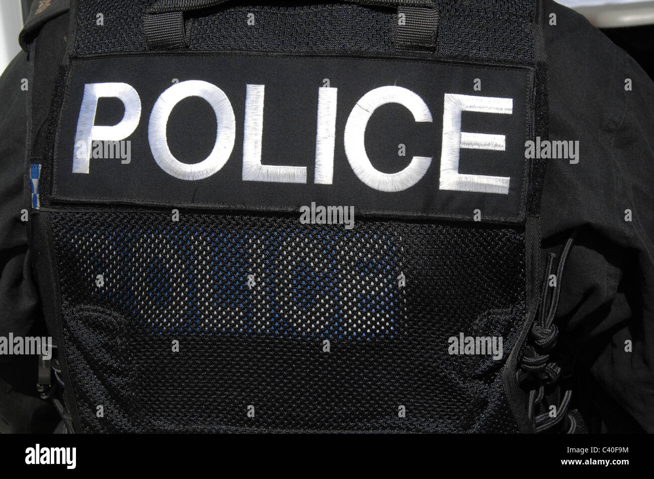 Un grande logo di polizia sul sulla parte posteriore di un ufficiale di SWAT il gilet tattico. Foto Stock