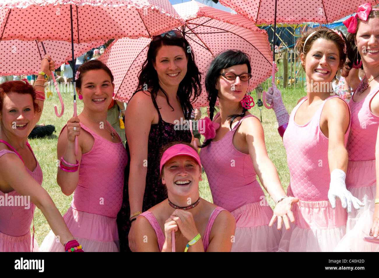 2010 Glastonbury Festival of Contemporary Performing Arts Festival troupe ragazze abiti rosa ombrelloni ballerine di danza atto Foto Stock