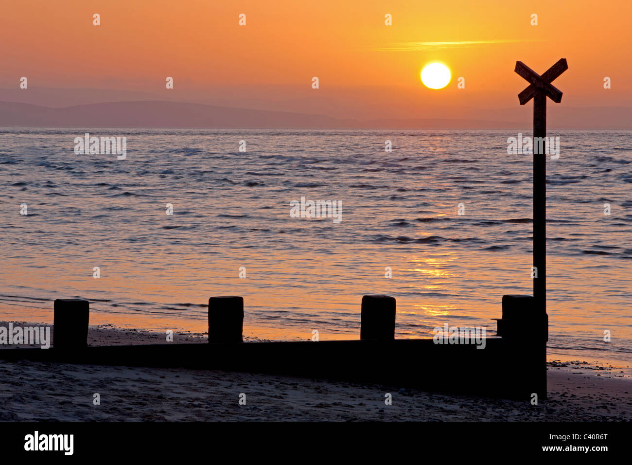 Tramonto a Findhorn fin oltre il frangiflutti (pennelli), Moray Firth, Scozia Foto Stock