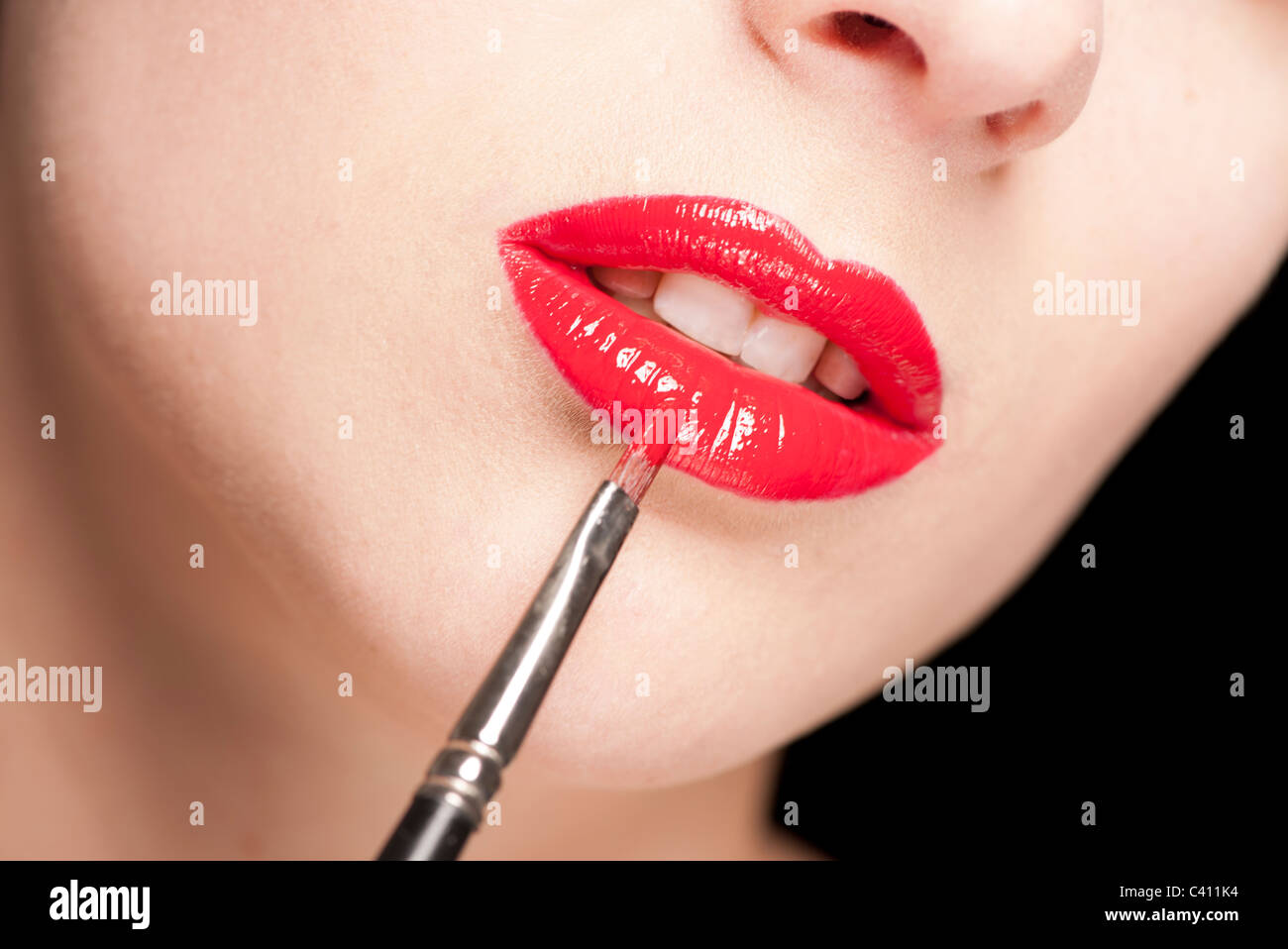 Donna Di Applicare Lucidalabbra Rosso Con Una Spazzola Foto Stock Alamy