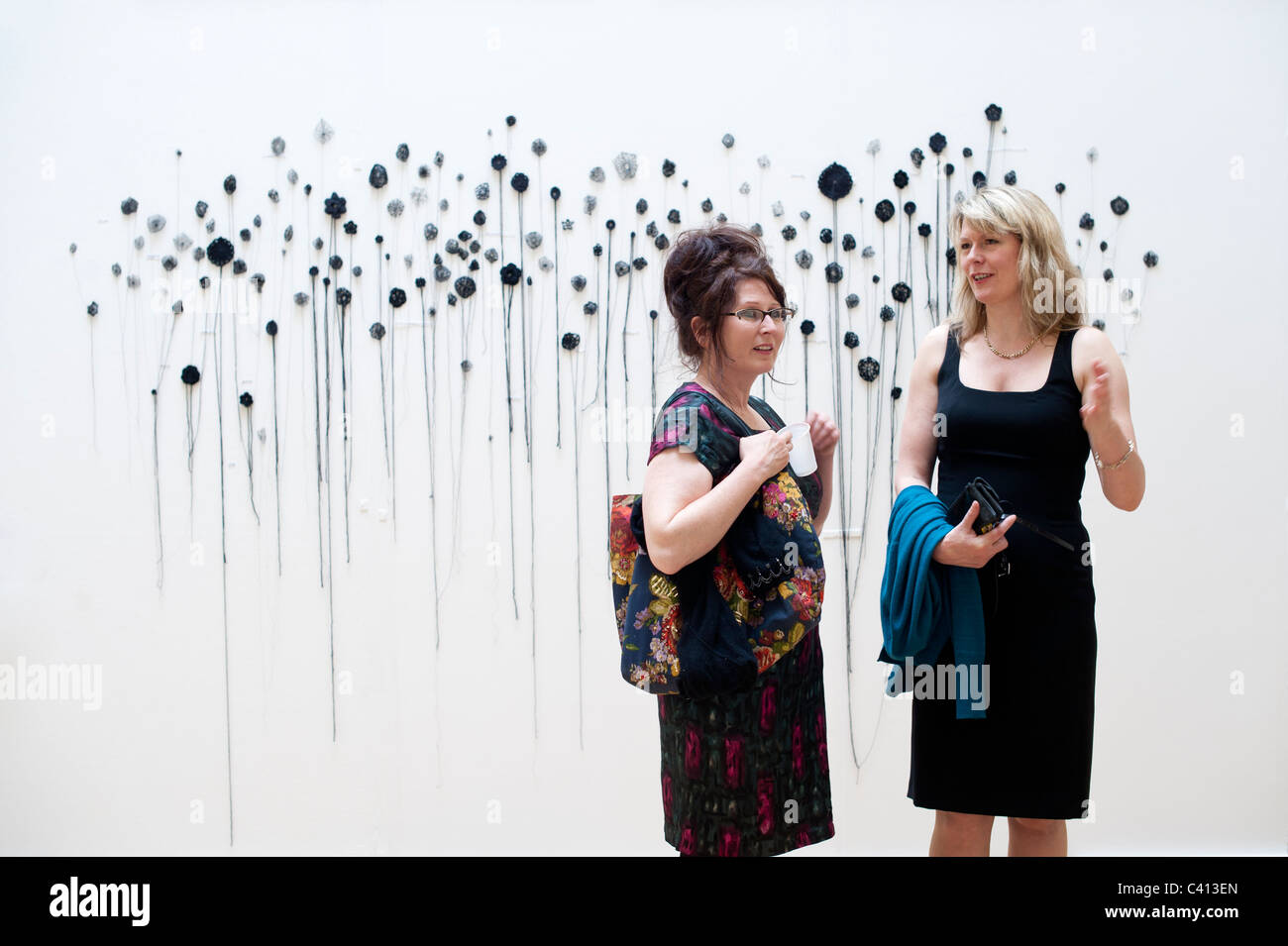 Due donna nella gallery in corso di laurea visualizza mostra nella scuola di arte Aberystwyth University, Wales UK Foto Stock