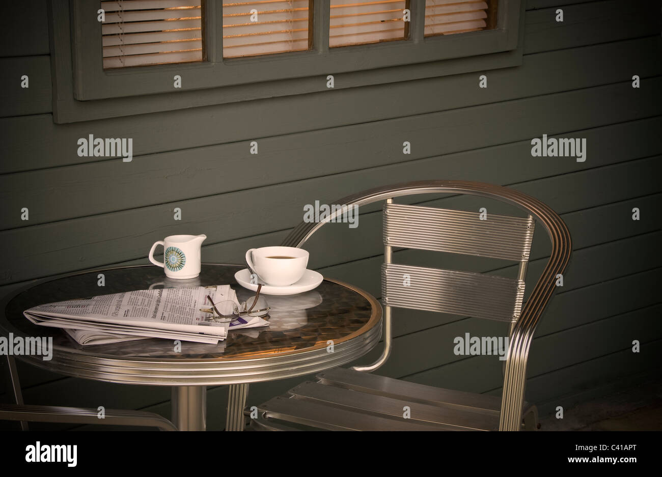 Tazza di caffè e quotidiano, su un tavolo all'esterno. Foto Stock