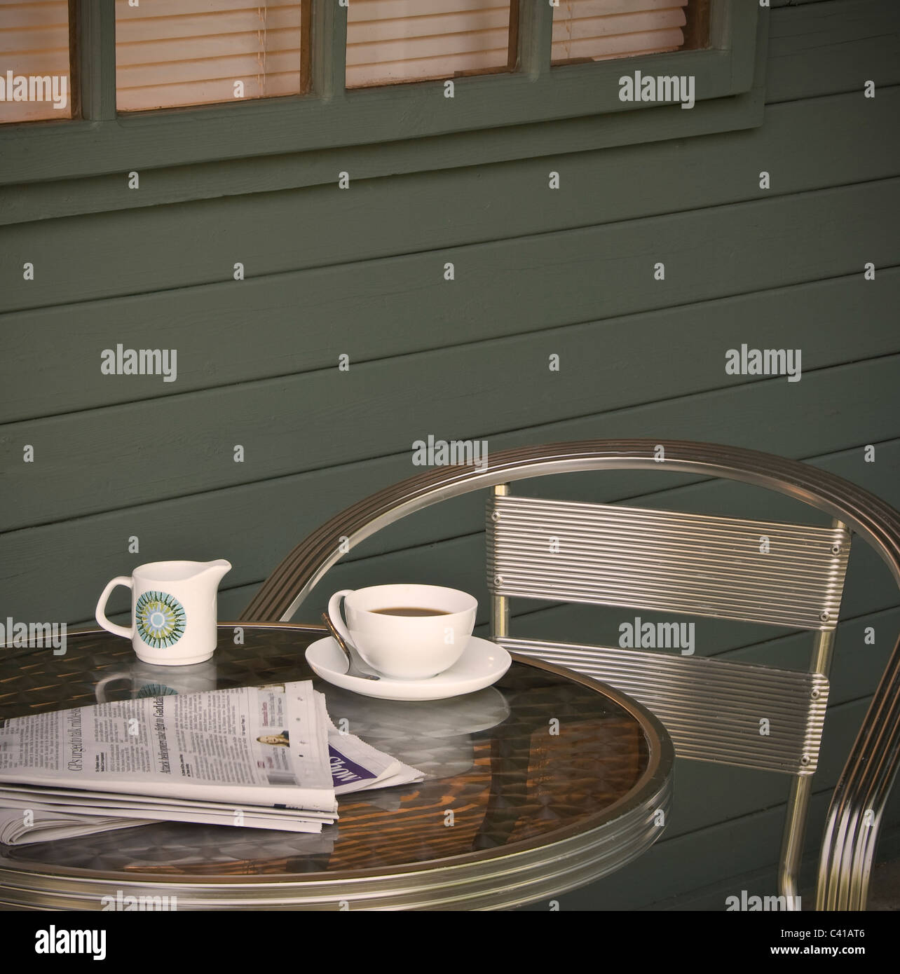 Tazza di caffè e quotidiano, su un tavolo all'esterno. Foto Stock