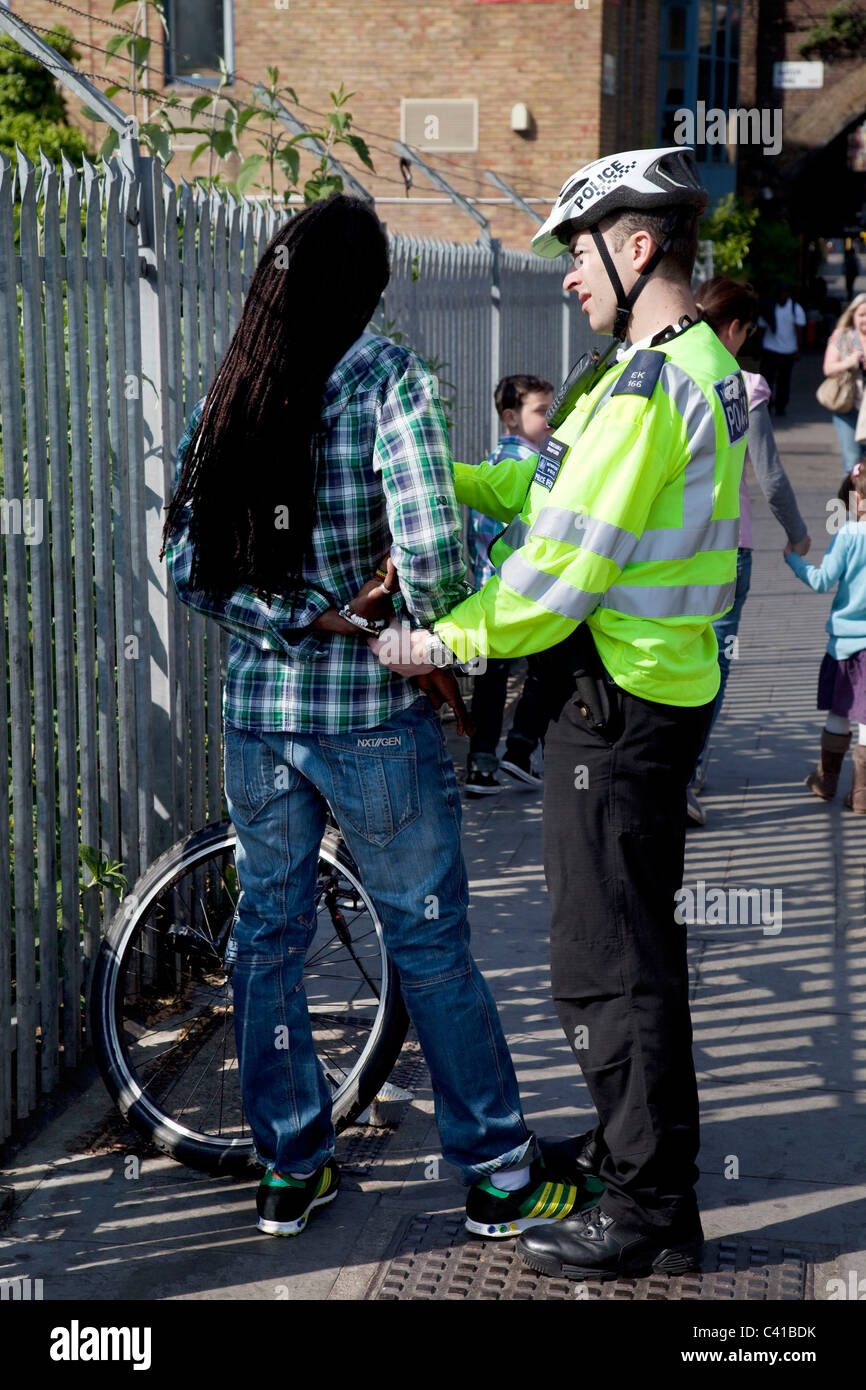 Maschio nero di essere arrestati dopo l'arresto e la ricerca da parte di un funzionario di polizia di Londra, Regno Unito. Foto Stock