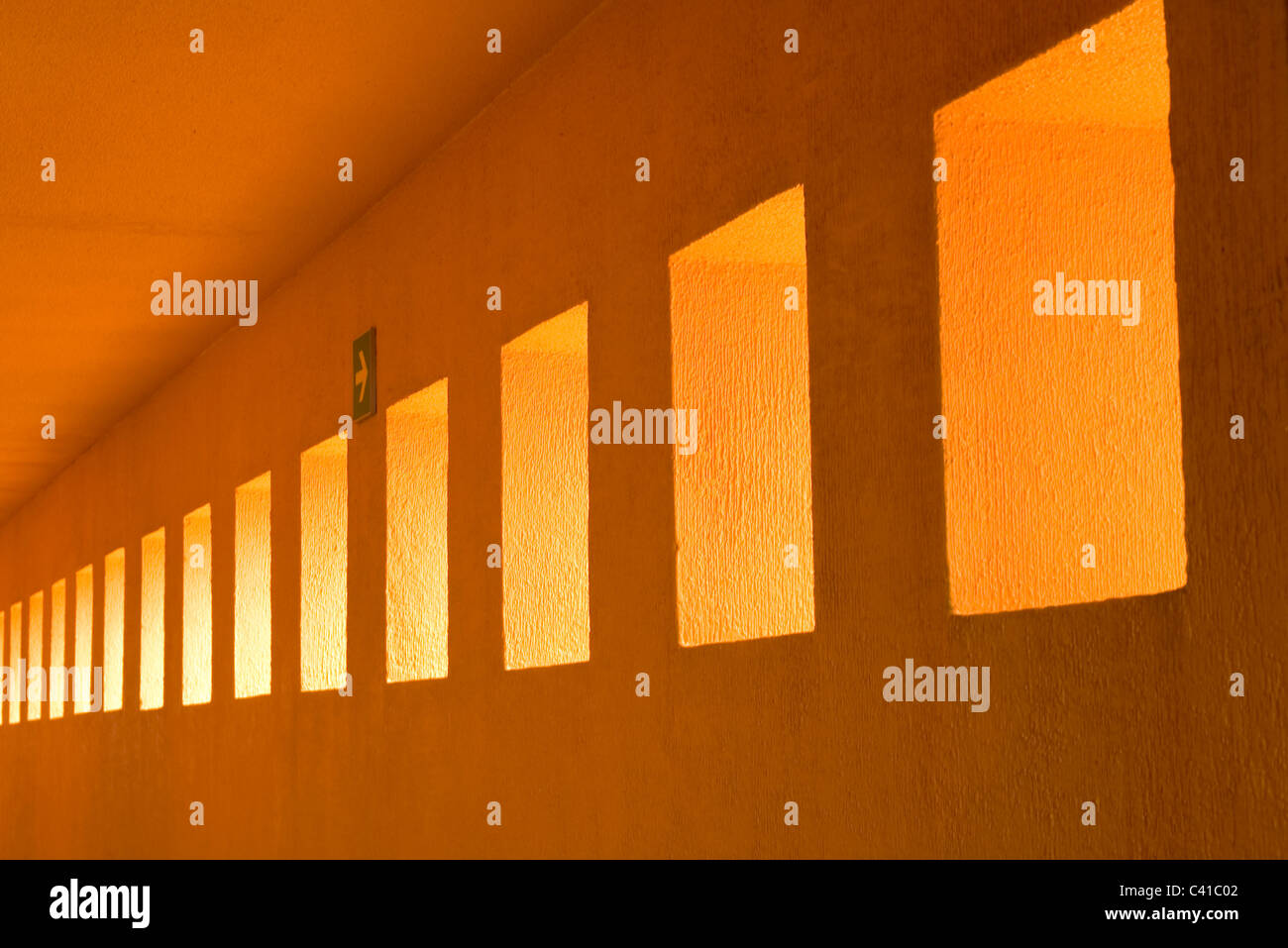 Foto astratte di forme geometriche che mostra una fila di parete rettangolare intagli che conduce a un punto di fuga lungo una parete di portico Foto Stock