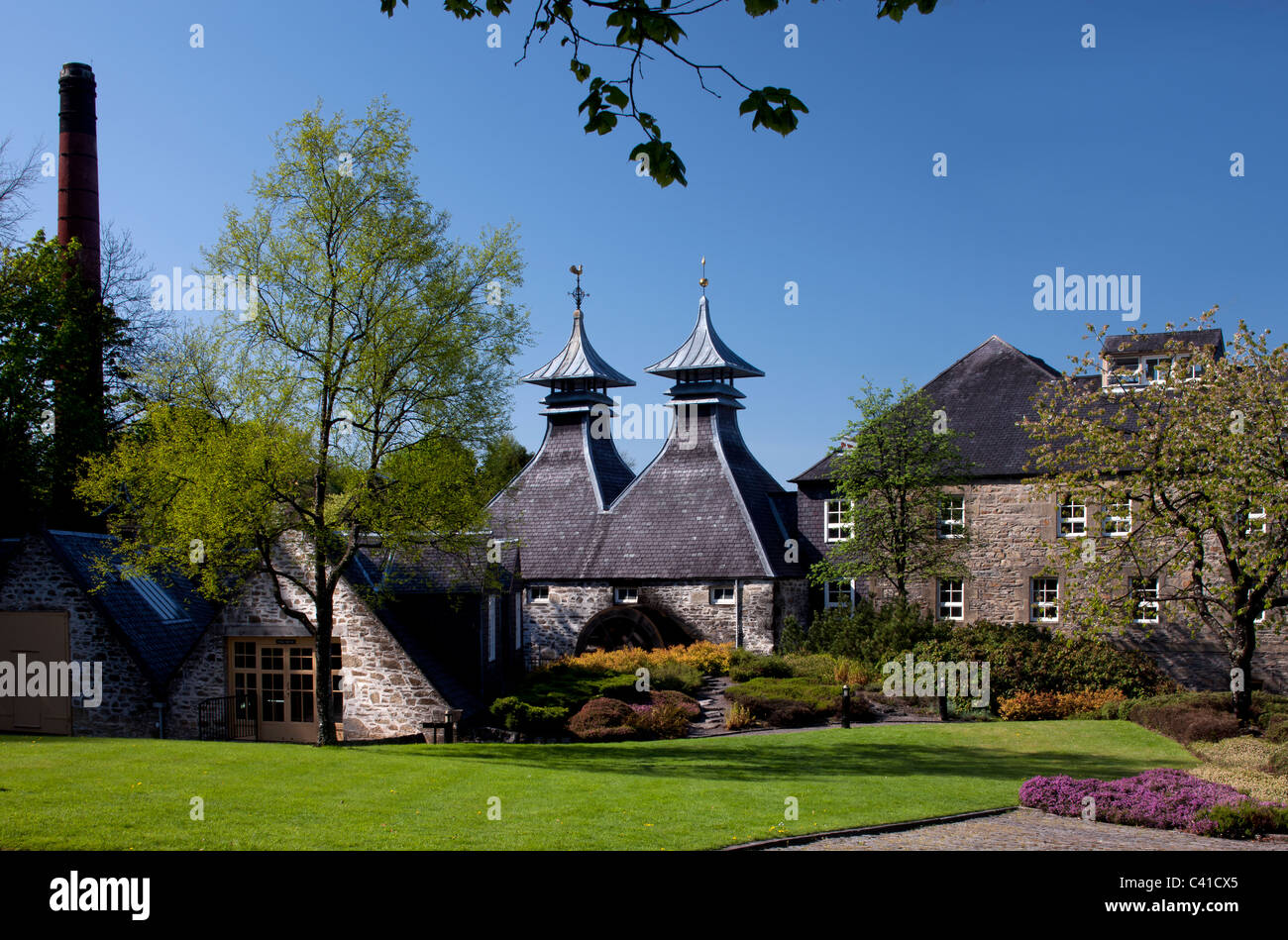 Primavera colpo di Strathisla Distillery, con fiori di primavera, a Keith, Banffshire, Scozia (Moray Firth) Foto Stock