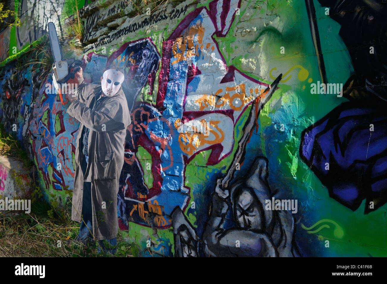 Pericoloso motosega mascherato armato con l'uomo dalla parete di graffiti composito di Toronto Foto Stock