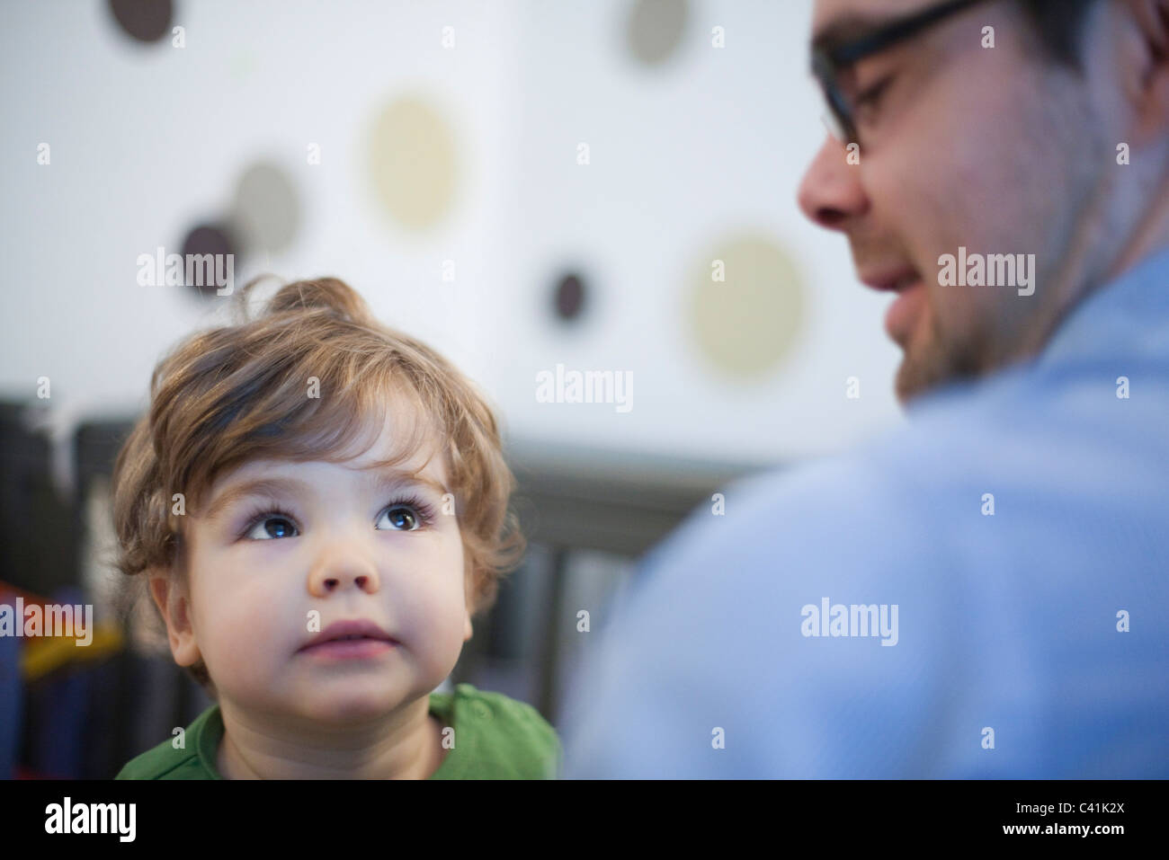 Il Toddler boy guardando attentamente al padre Foto Stock