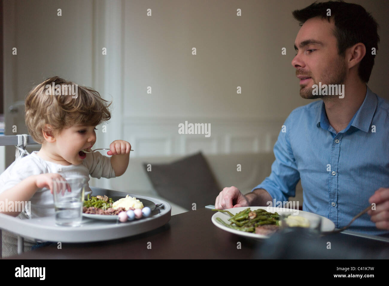 Padre e figlio dei bimbi di mangiare la cena insieme Foto Stock