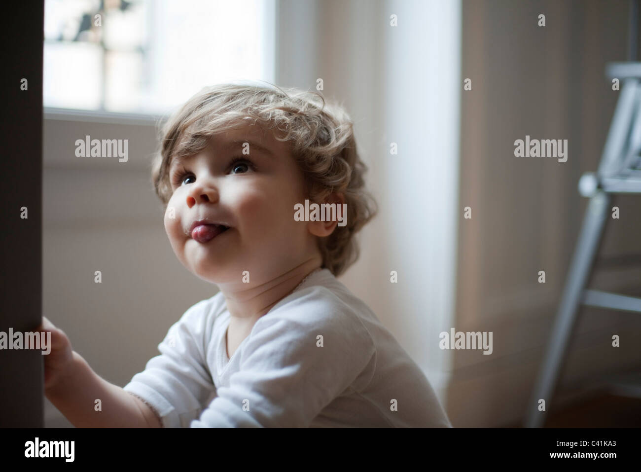 Il Toddler Ragazzo spuntavano lingua, guardando in alto, ritratto Foto Stock