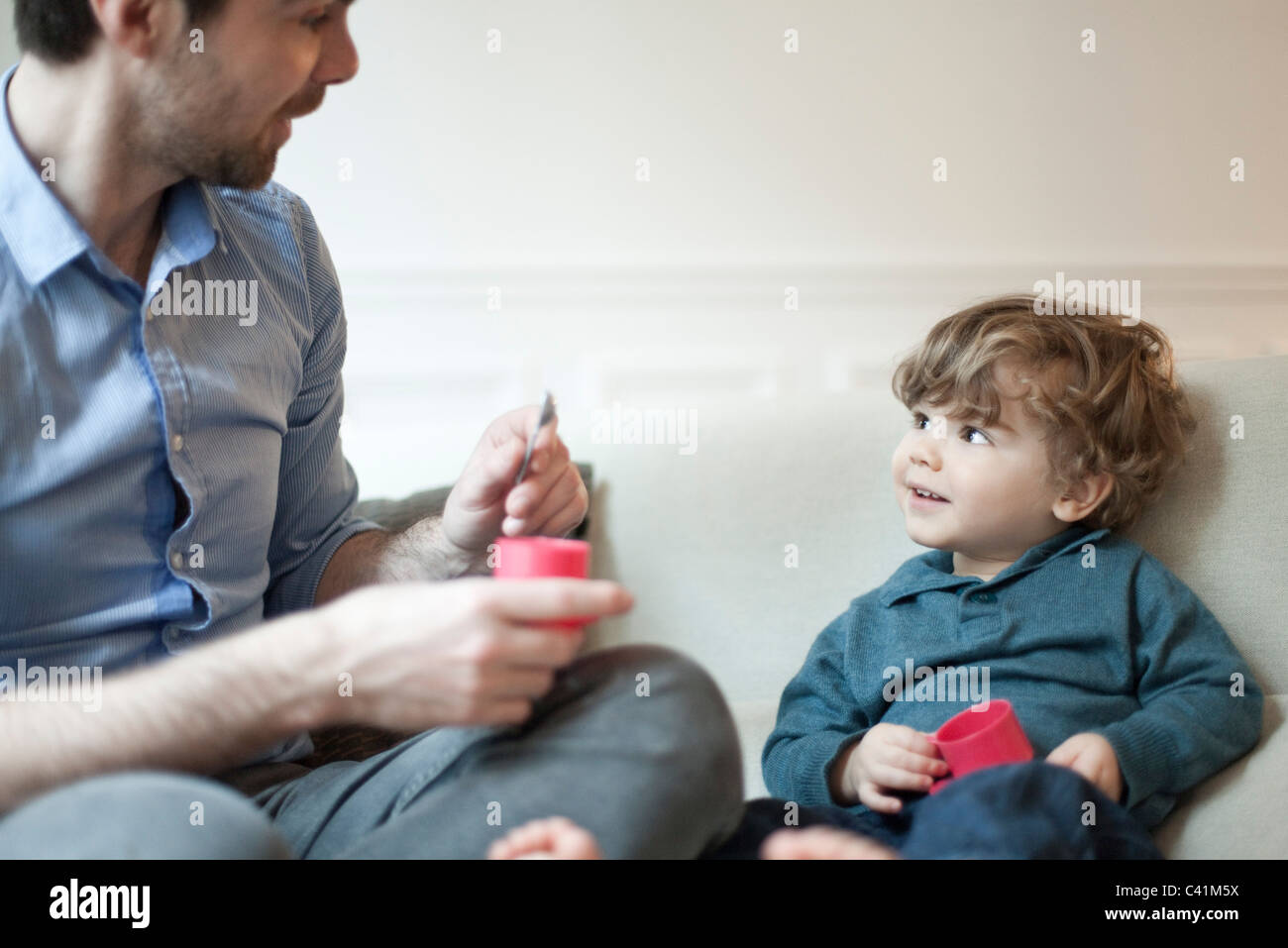 Padre e figlio giovane giocando con il giocattolo set da tè Foto Stock