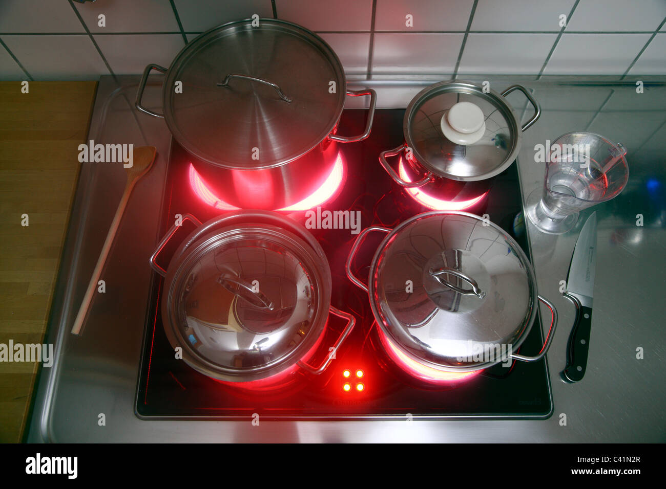 Cucina casalinga, pentole, realizzata in acciaio inossidabile, su di un vetro caldo-cottura ceramica anello. red hot incandescente. Foto Stock