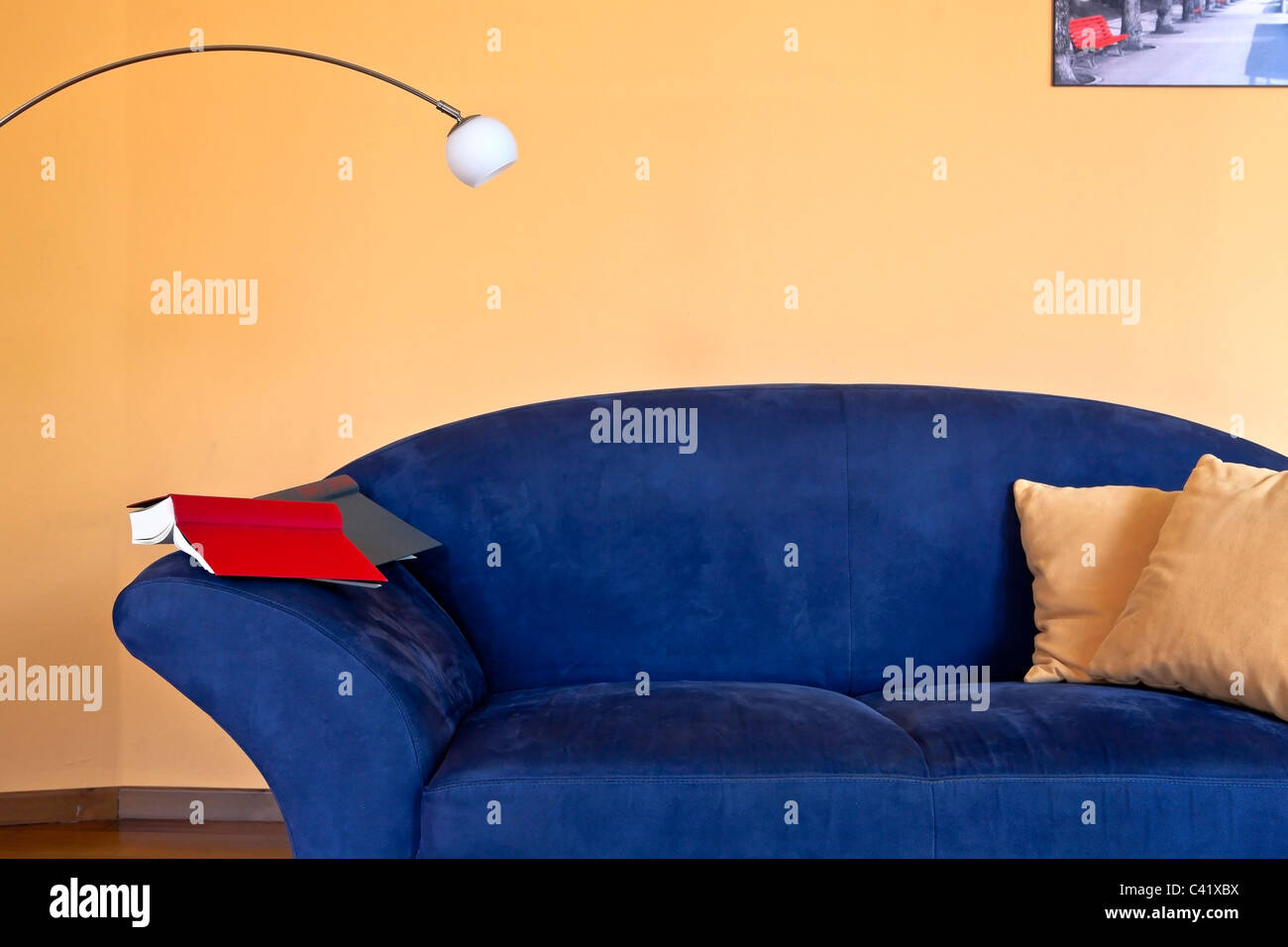 Un angolo lettura con un lettino blu, un libro e una lampada da lettura Foto Stock