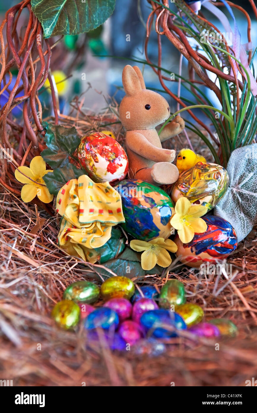 Un coniglietto di pasqua con le uova di Pasqua in un nido di paglia Foto Stock