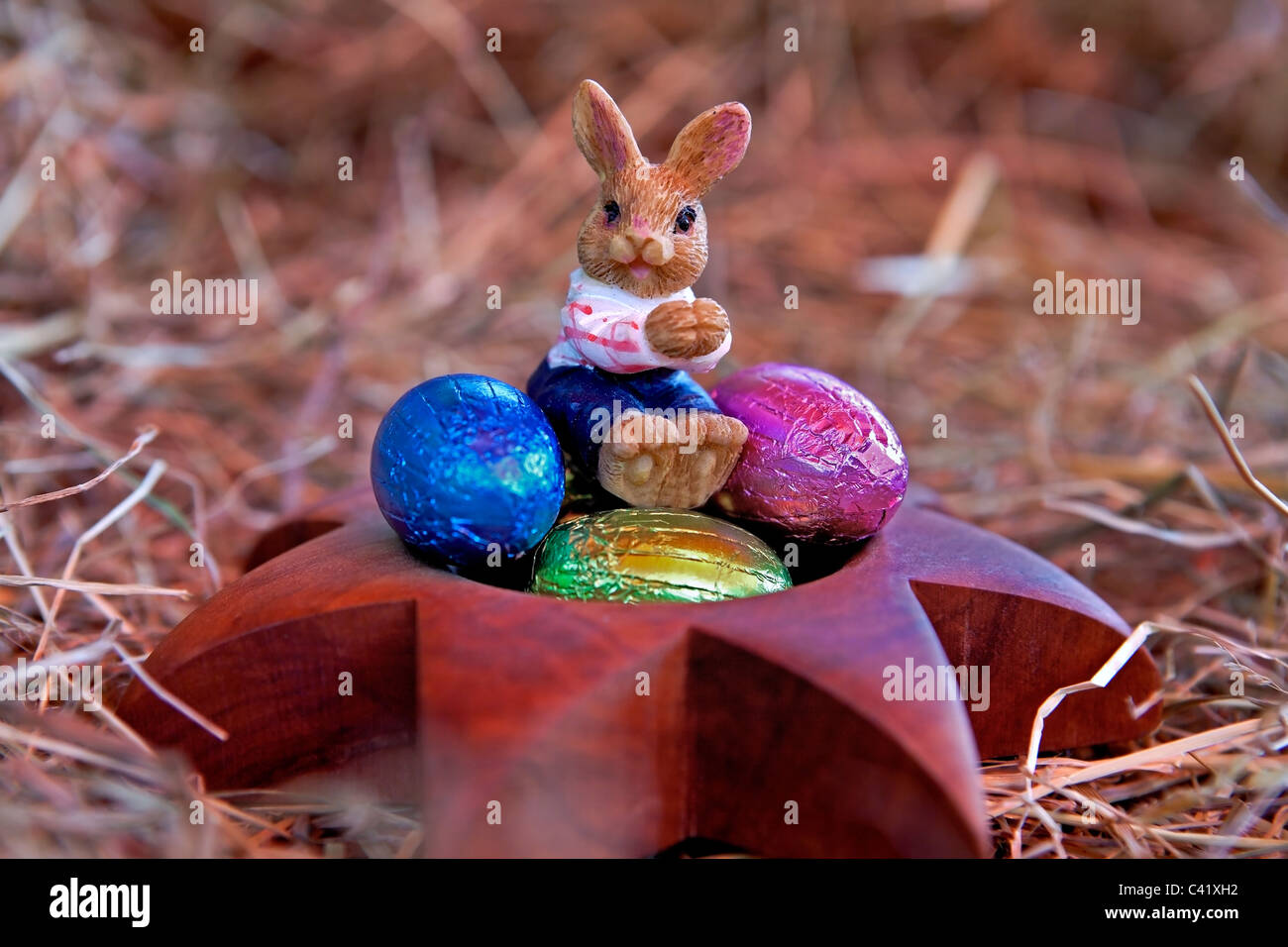 Un coniglietto di pasqua con le uova di Pasqua in un nido di paglia Foto Stock