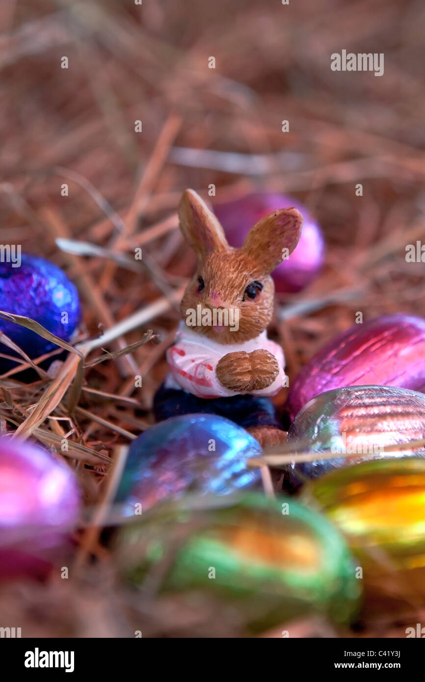 Un coniglietto di pasqua con le uova di Pasqua in un nido di paglia Foto Stock