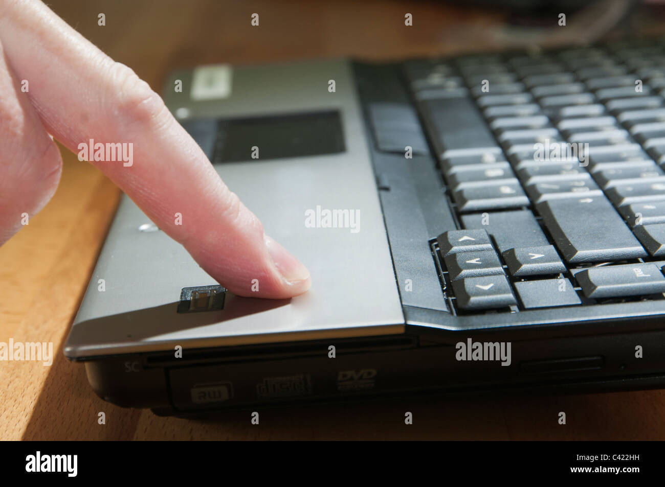 Utente scorrendo un dito sul finger print scanner sul computer portatile Foto Stock