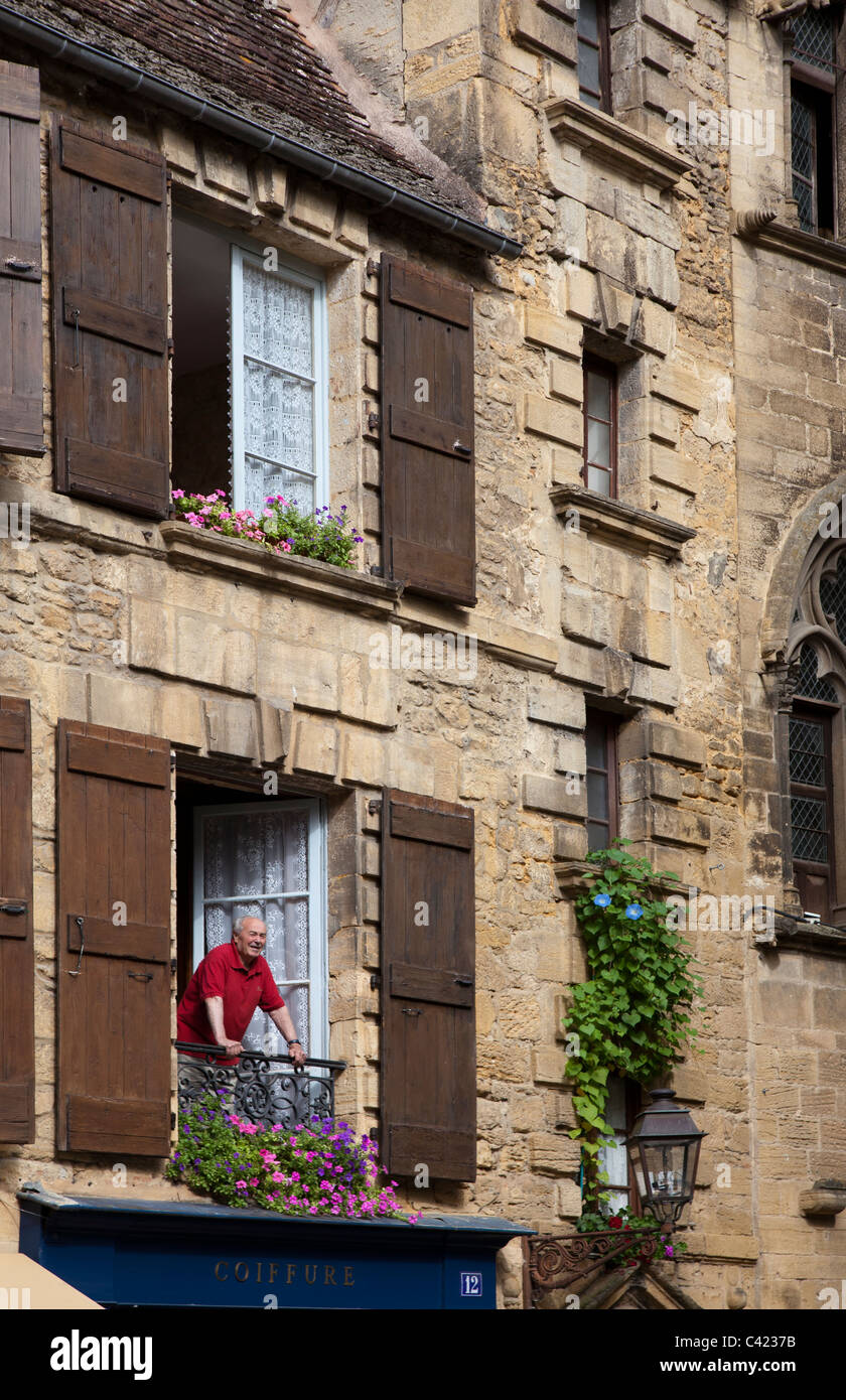 Uomo in finestre del balcone Sarlat-la-Caneda Dordogne Francia Foto Stock