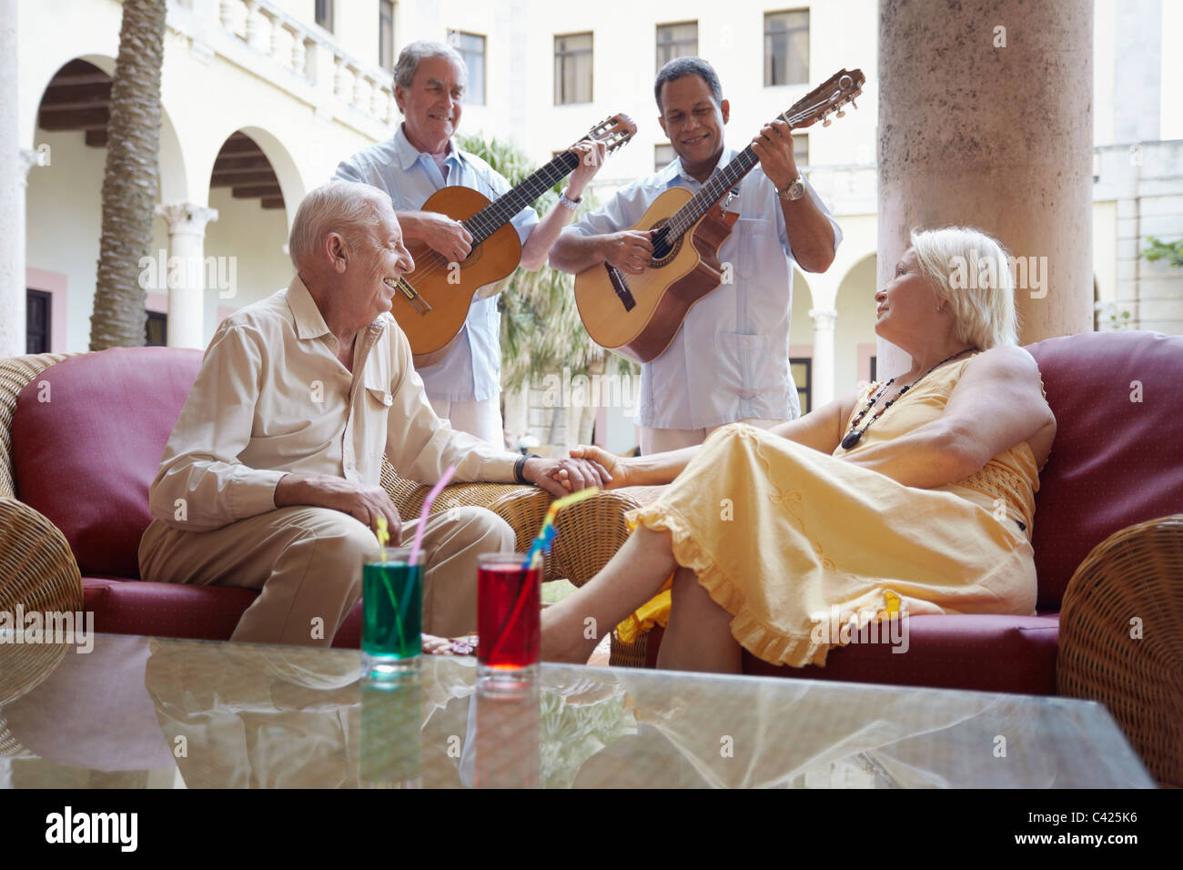 Senior caucasian giovane seduto nel bar dell hotel e ascolto di musicisti a suonare la chitarra. Forma orizzontale Foto Stock
