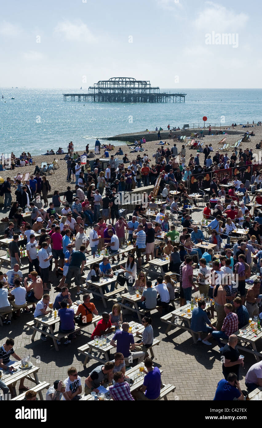Una folla di persone in un bar sul lungomare di Brighton. Foto Stock