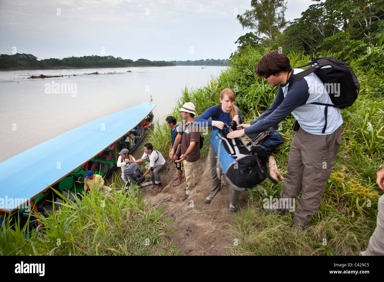 Il Perù, Boca MANU Manu National Park, sito Patrimonio Mondiale dell'UNESCO, il fiume Rio Madre de Dios. I turisti in barca di scarico. Foto Stock