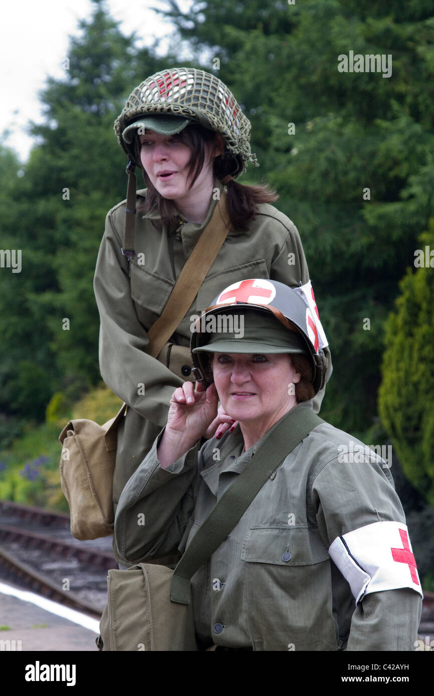 La Seconda Guerra mondiale, durante la seconda guerra mondiale donna americana medic, Croce Rossa rievocazione a British Railway Station _il 1940'3 Weekend di guerra gli attori a stazione di Lancaster, Lancashire, Maggio 2011 Foto Stock