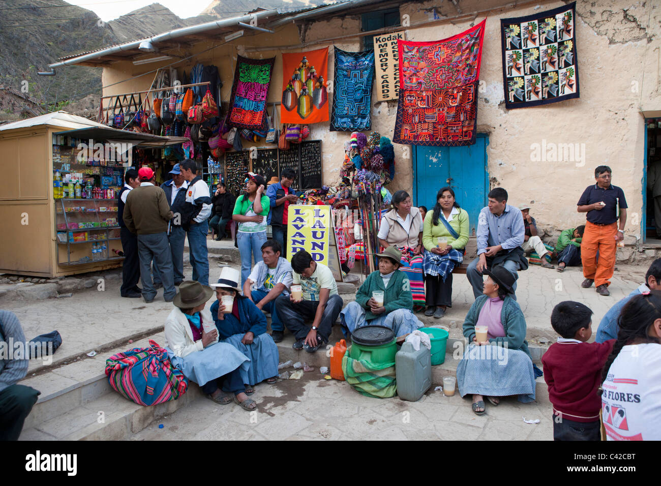 Il Perù, Ollantaytambo, gente beve chicha, la birra indiana fatta di mais, sulla piazza principale. Foto Stock