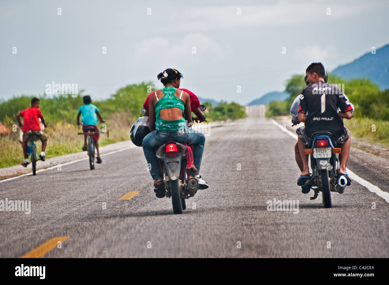 Motociclette e biciclette viaggiando su strada aperta attraverso la campagna brasiliana Pernambuco Brasile Foto Stock