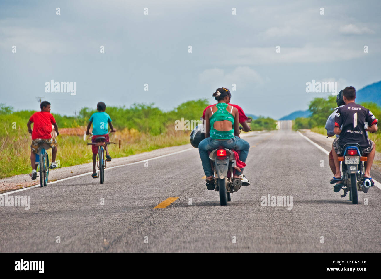 Motociclette e biciclette viaggiando su strada aperta attraverso la campagna brasiliana Pernambuco Brasile Foto Stock