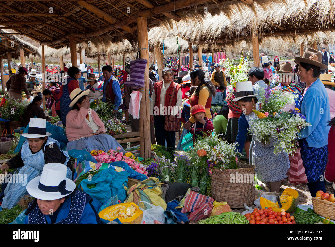 Il Perù, Chinchero, donne sul mercato di vendita e di acquisto di frutta, fiori e verdure. Foto Stock