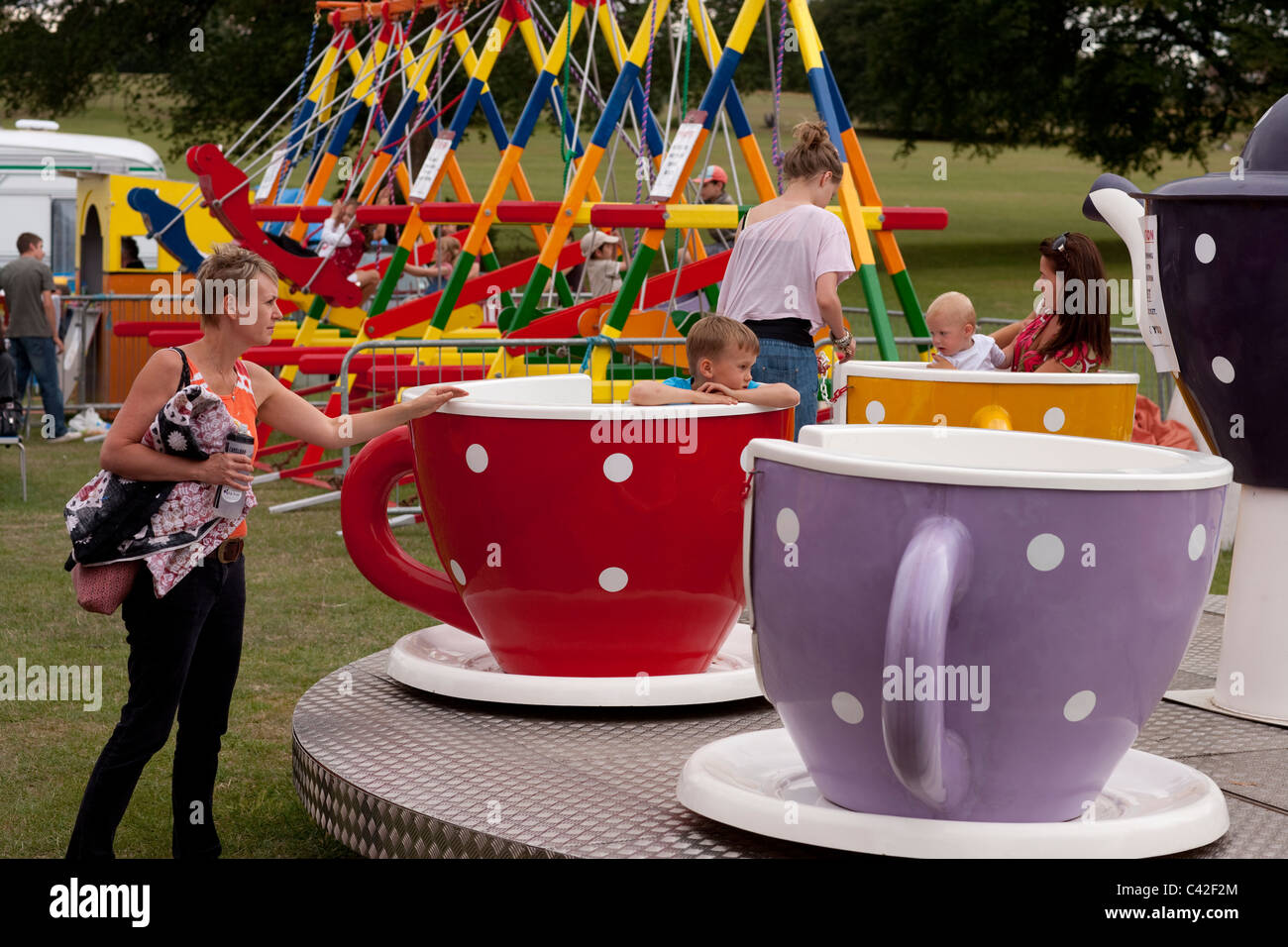 La ricreazione. Altalene e Teacups Gigante, della fiera. Verulamium Park, St. Albans, Hertfordshire. Foto Stock