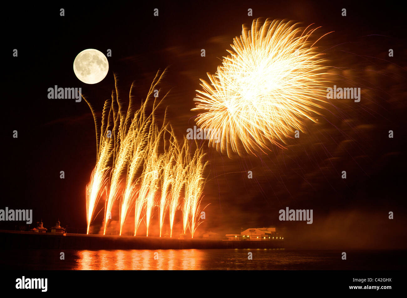 Luna piena e fuochi d'artificio su pier Foto Stock