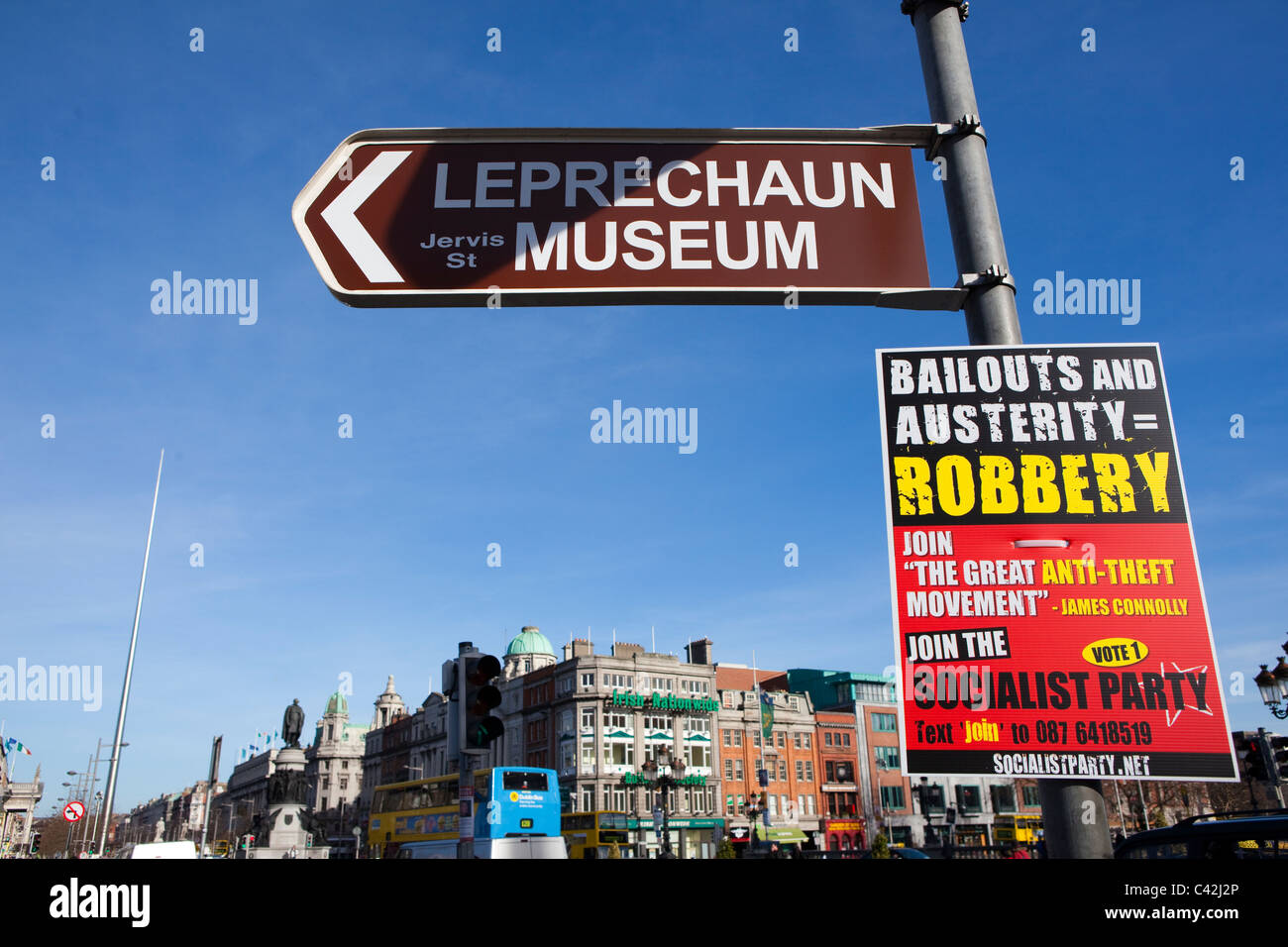 Segno per Leprechaun museum, a ponte O'Connell, Dublino, Irlanda, con manifesto politico a seguito della crisi finanziaria Foto Stock