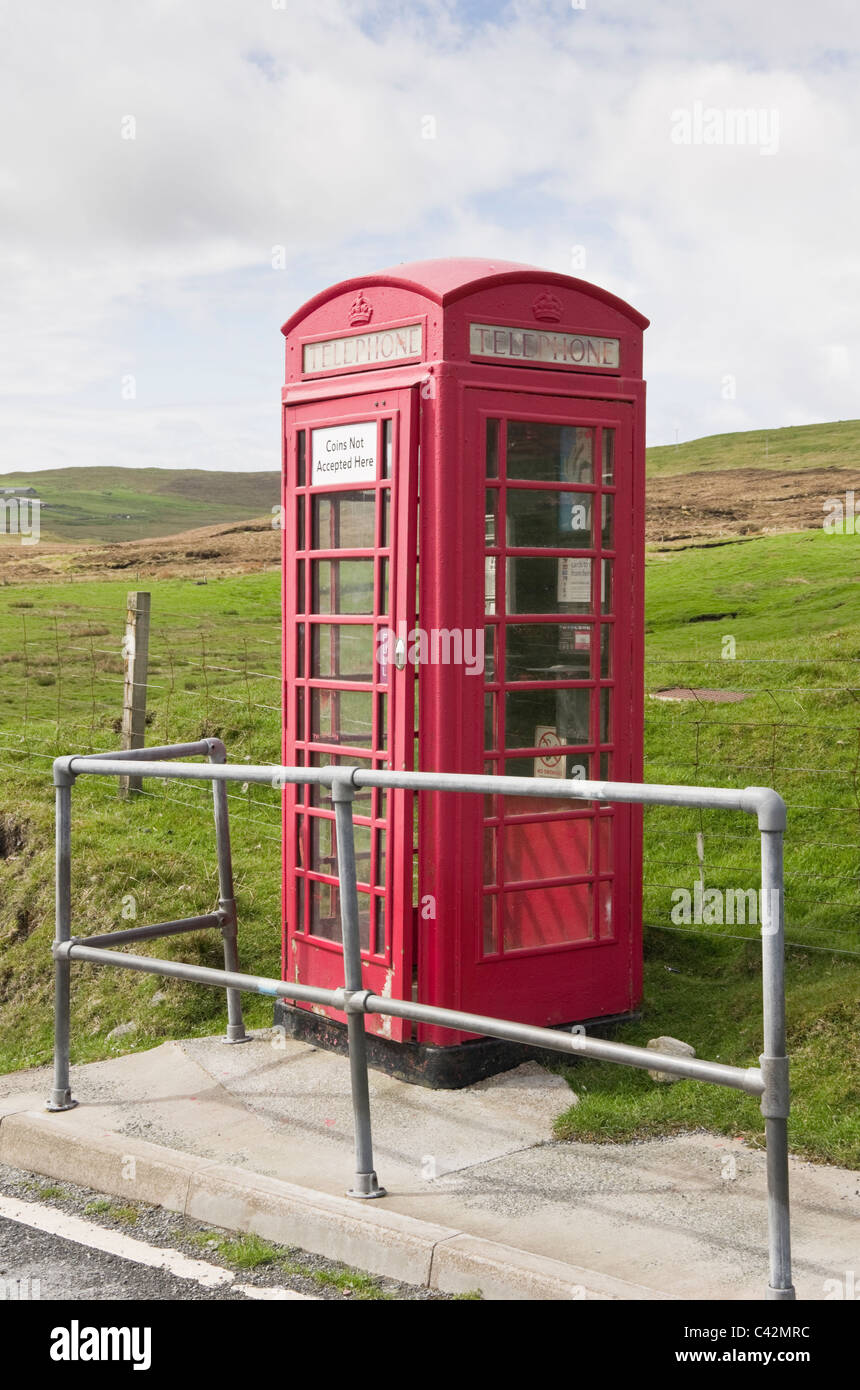 Voe, Northmavine, isole Shetland, Scotland, Regno Unito. Rosso rurale chiosco telefono accetta soltanto carte. Foto Stock
