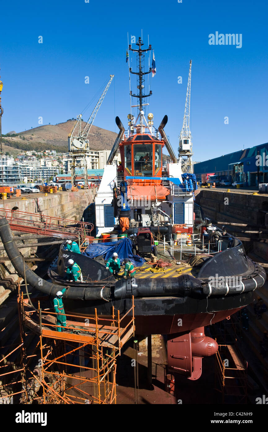 I lavoratori della riparazione di un rimorchiatore a traino in un bacino a secco a Città del Capo in Sud Africa Foto Stock